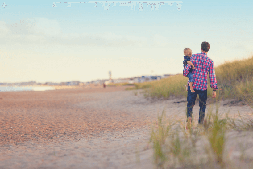 8 Tips to Thrive as a Single Parent: Man walking on the beach and carrying little boy